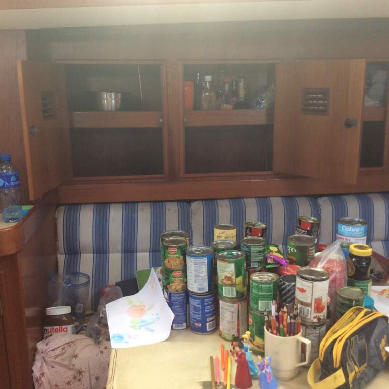 Cans on the table and an empty cupboard